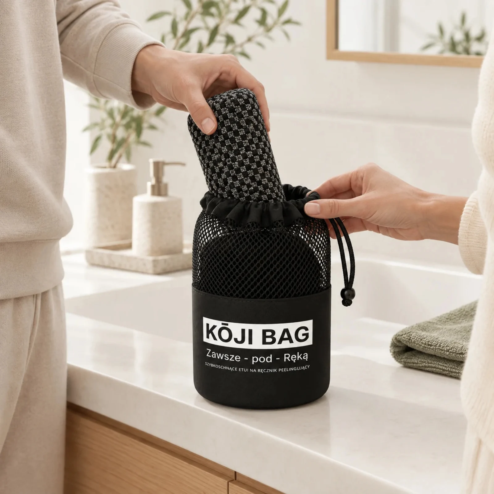 Wkładanie złożonego ręcznika Kōji Towel do otwartego etui Kōji Bag