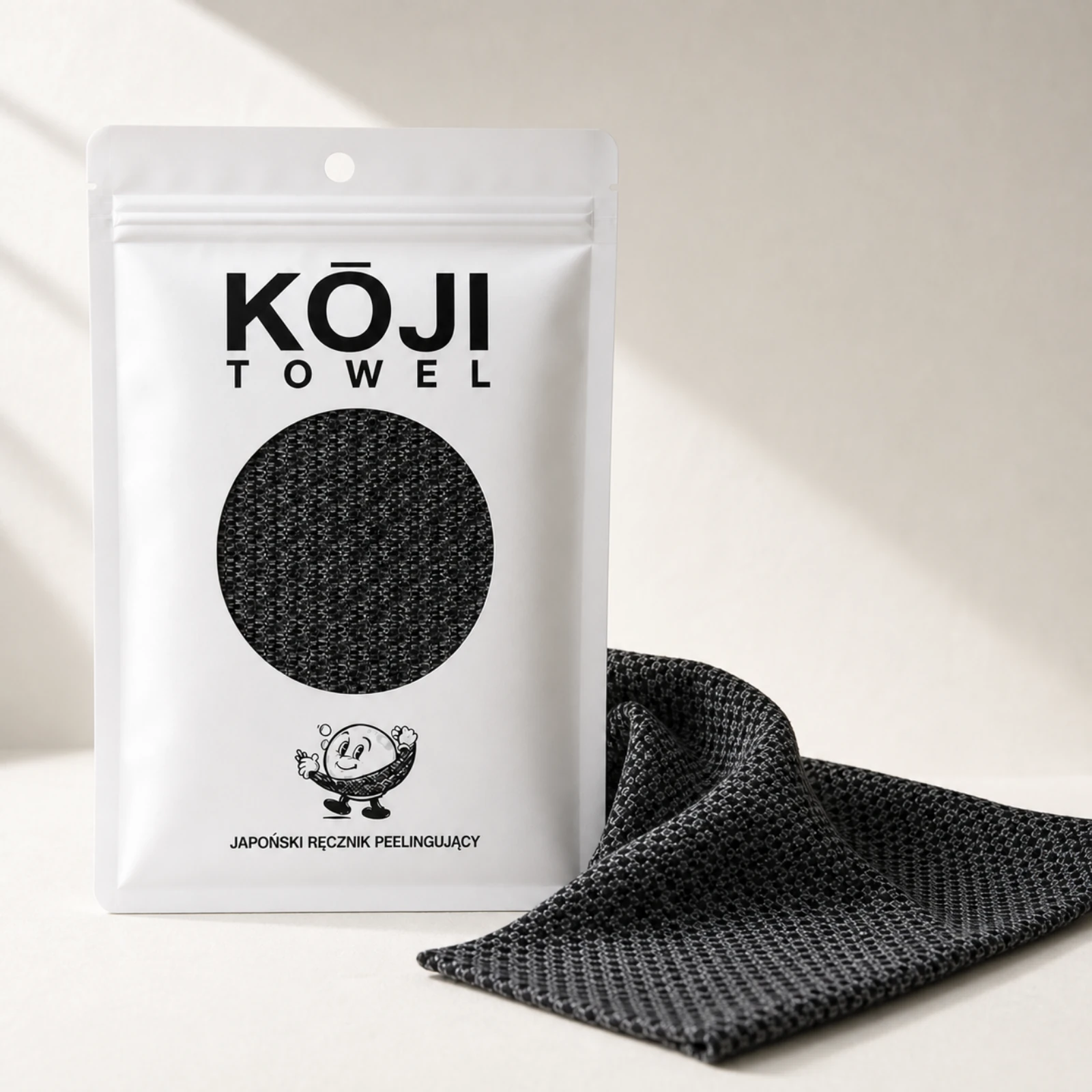 Czarny Kōji Towel obok białego opakowania
